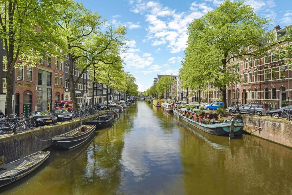 a canal with boats in a city with buildings at Six in Amsterdam