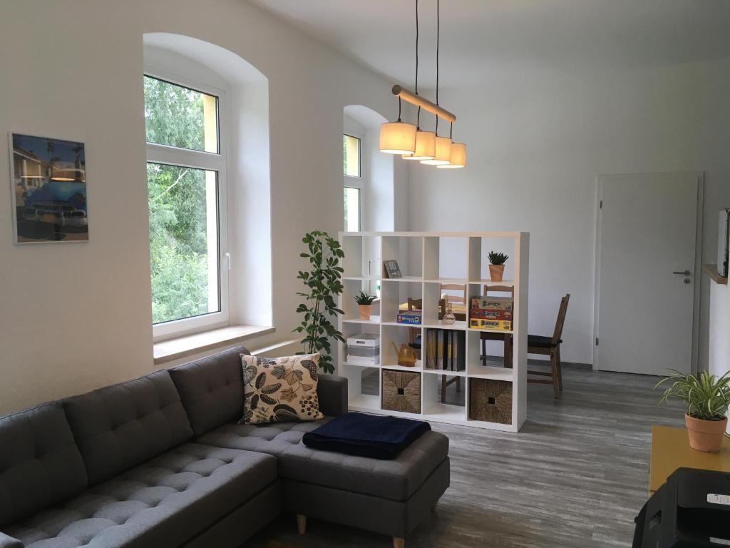 Una sala de estar con un sofá y una estantería. en Der graue Salon, en Annaberg-Buchholz