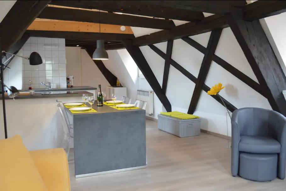 a kitchen with a counter and a blue chair at Bretzel &amp; Raisin - Hypercentre de Colmar in Colmar
