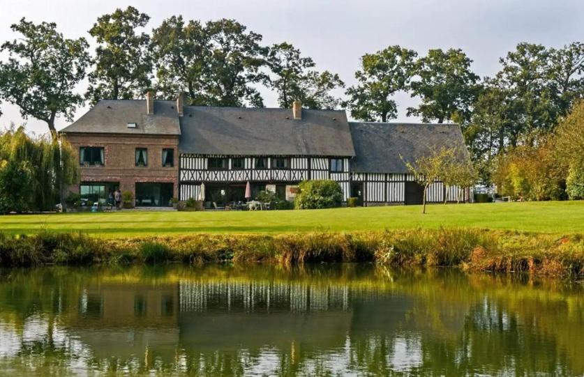 um grande edifício ao lado de uma massa de água em Le Manoir de la Campagne em Yébleron