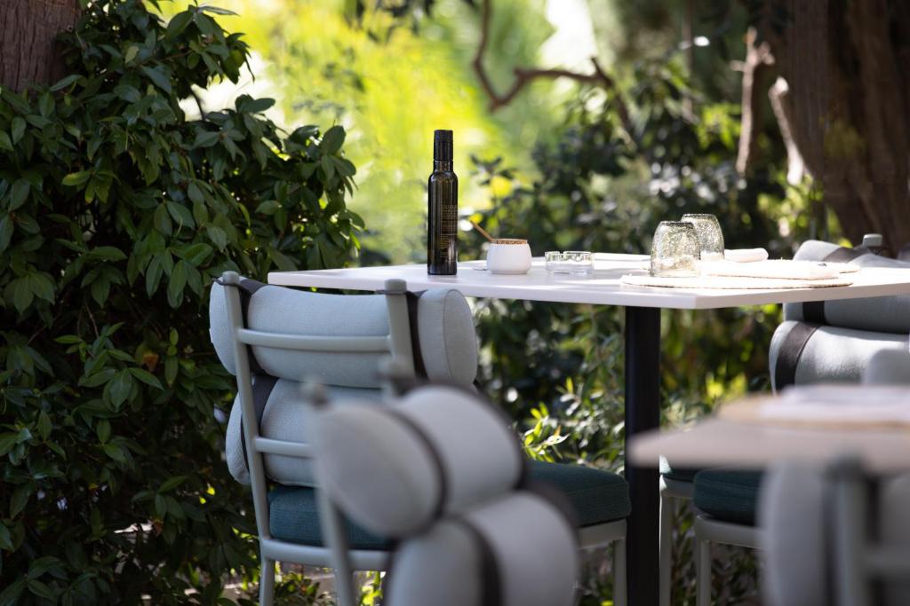 a white table with chairs and a bottle of wine on it at Hotel Royal-Riviera in Saint-Jean-Cap-Ferrat