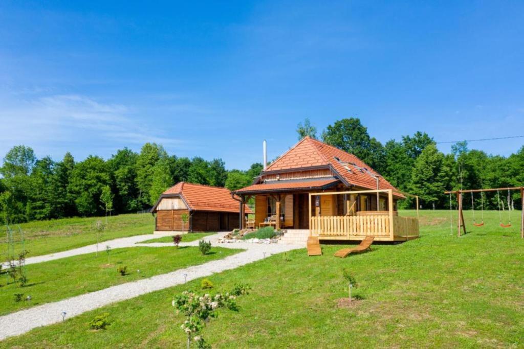 a large house in a field next to a soccer field at Chalet Markoci With Hot Tub - Happy Rentals in Rakovica