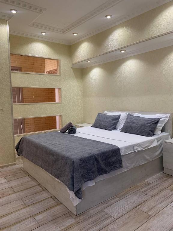 ein Schlafzimmer mit einem großen Bett in einem Zimmer in der Unterkunft LUX in Schymkent