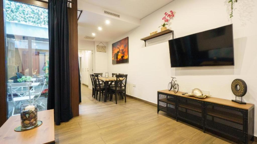 ein Wohnzimmer mit einem TV und einem Esszimmer in der Unterkunft RentalSevilla Looks Pretty and modern in Sevilla