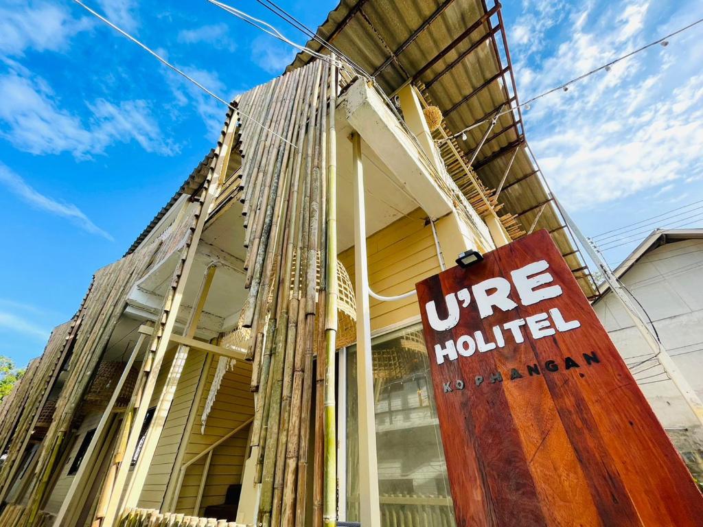 a building with a weathered sign in front of it at U're Holitel in Haad Rin