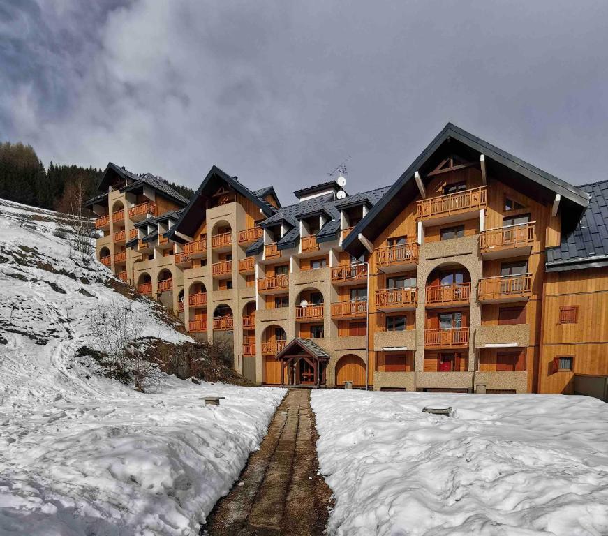 a large building with snow in front of it at Pluton B63 in Les Deux Alpes