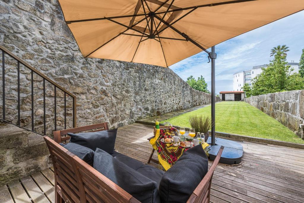 een patio met een tafel en een parasol bij GuestReady - La Maison Aires Gouveia 3 in Porto