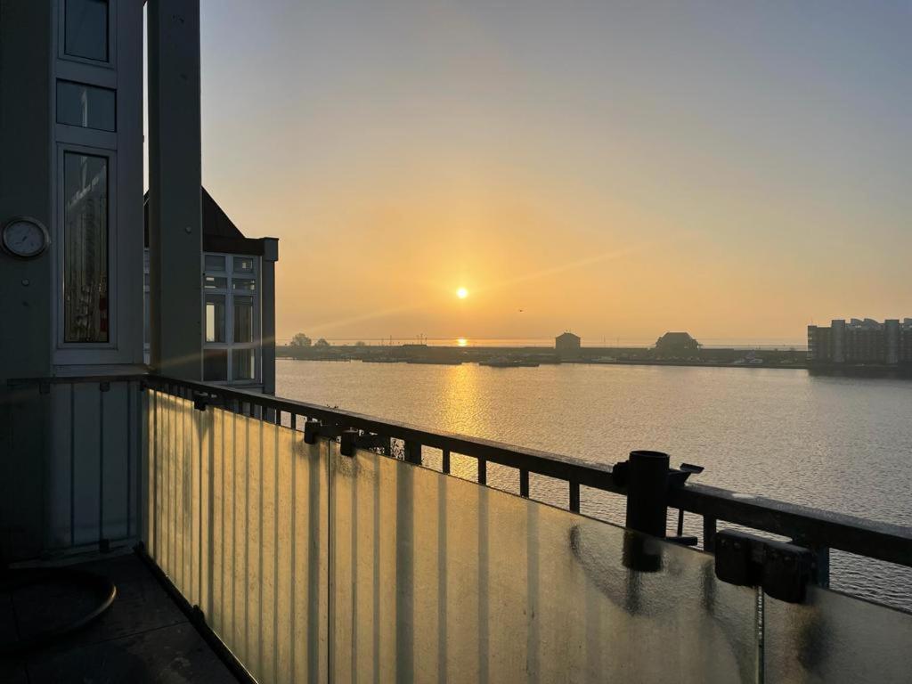 einen Blick auf den Sonnenuntergang vom Balkon eines Hauses in der Unterkunft Ferienwohnung mit Blick aufs Meer in Wilhelmshaven in Wilhelmshaven