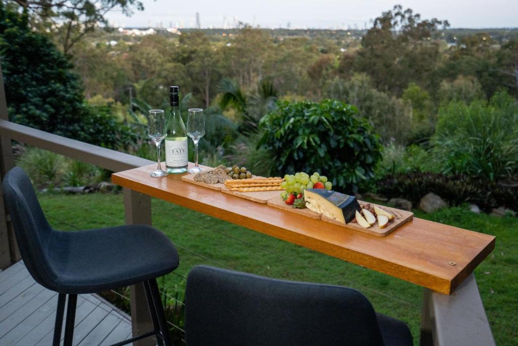 a table with a bottle of wine and cheese and wine glasses at Bushland Retreat in Gold Coast