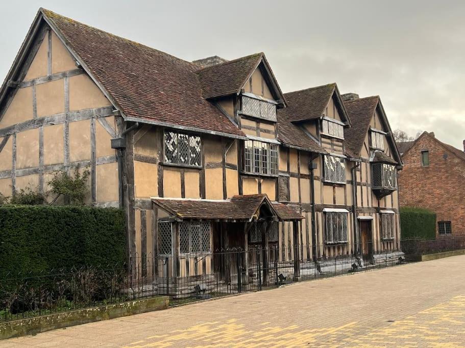 a large wooden building with windows on a street at Luxury Town centre apartment walking distance to RSC theatre in Stratford-upon-Avon