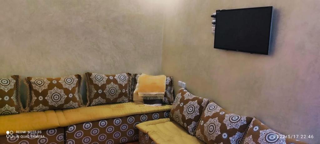 a living room with a couch and a flat screen tv at Residence el khannchi in Laayoune