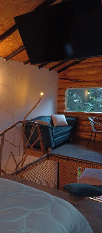 1 dormitorio con 1 cama, 1 silla y 1 ventana en Cabaña en la calera el Pinar en La Calera