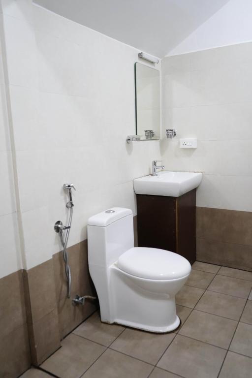 a bathroom with a toilet and a sink at Edens Munnar in Munnar