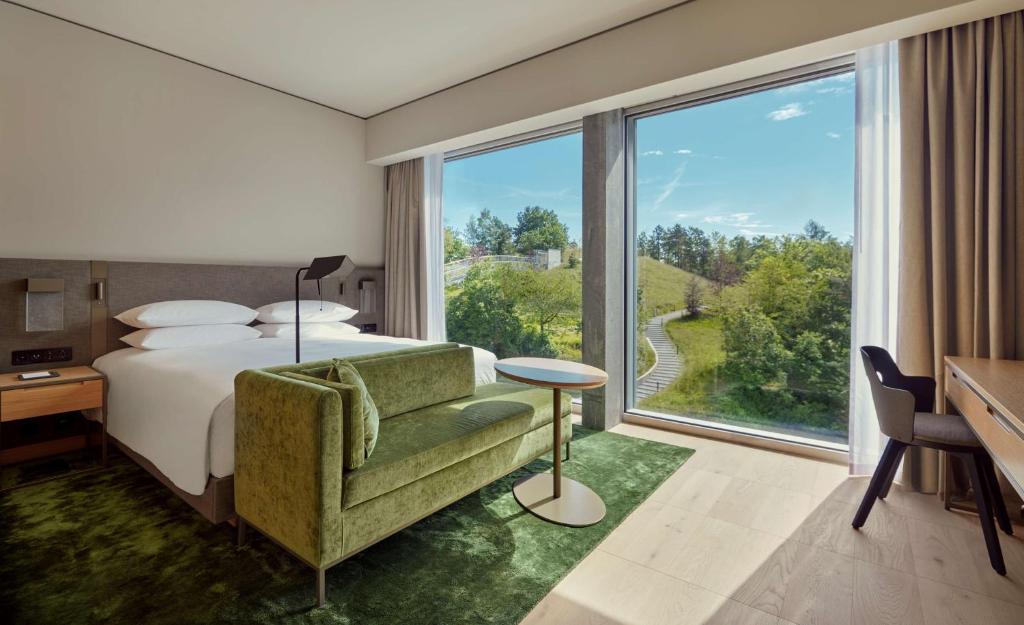 a hotel room with a bed and a large window at Hyatt Regency Zurich Airport Circle in Kloten