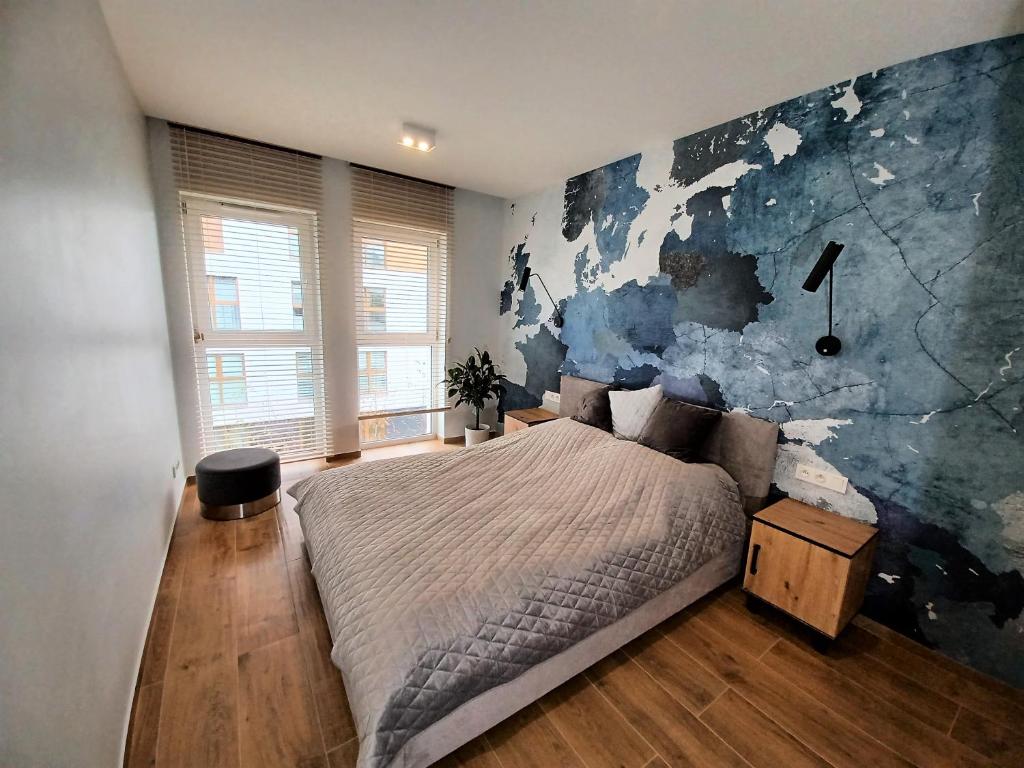 カトヴィツェにあるKima Apartament Bażantów 44のベッドルーム1室(大型ベッド1台、壁画付)