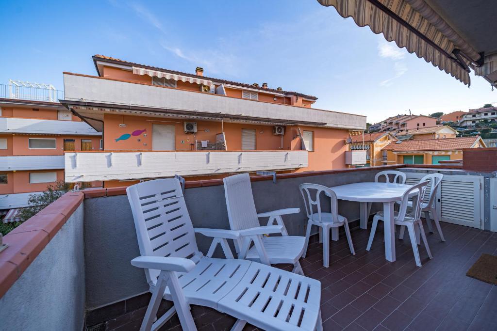 eine Terrasse mit Stühlen und einem Tisch auf dem Balkon in der Unterkunft Casa Felice a Porto Azzurro - Goelba in Porto Azzurro