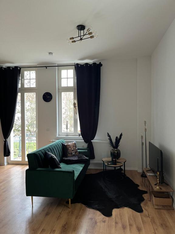 a living room with a green couch and a television at Cityliebe in Magdeburg
