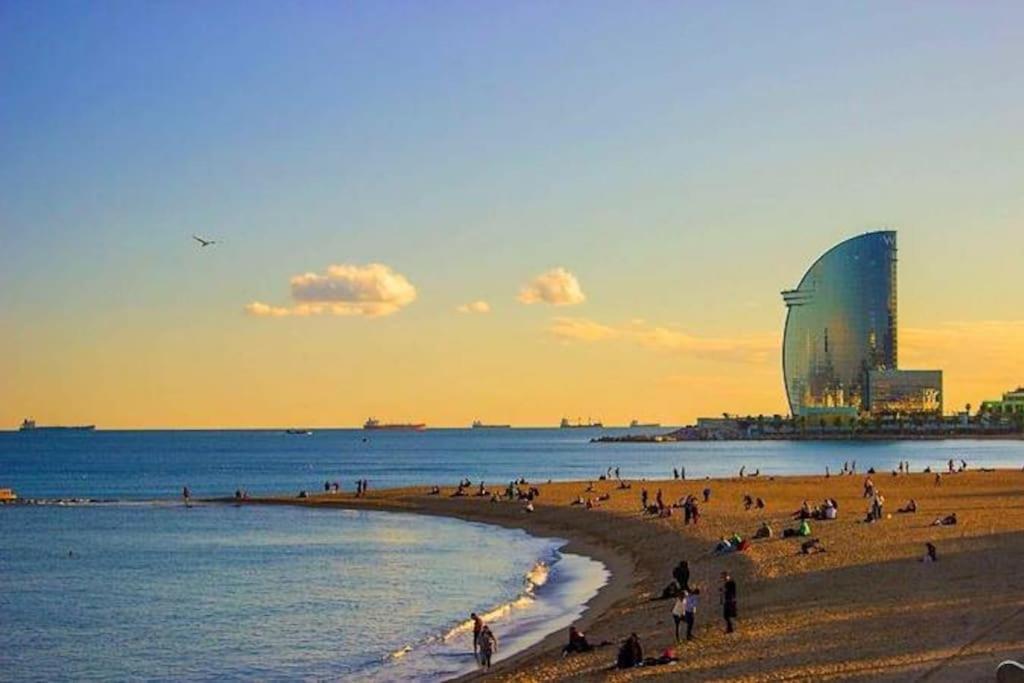 un grupo de personas en una playa al atardecer en Barcelona Beach Home, en Barcelona