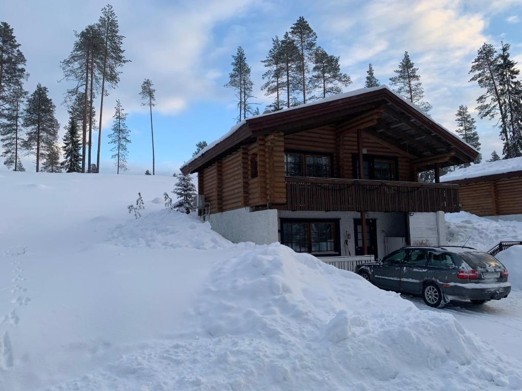 un coche aparcado frente a una casa cubierta de nieve en Mökki Uutela Taivalkoski, en Taivalkoski