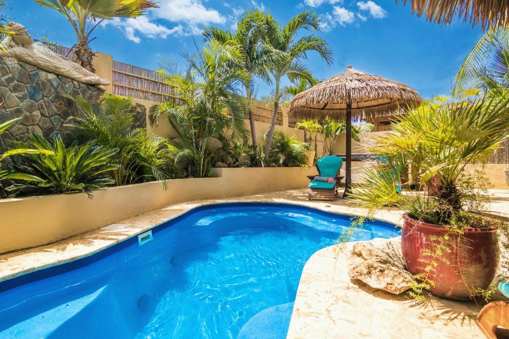 una piscina en un patio con un complejo en Bamboo Bonaire Boutique Resort, en Kralendijk