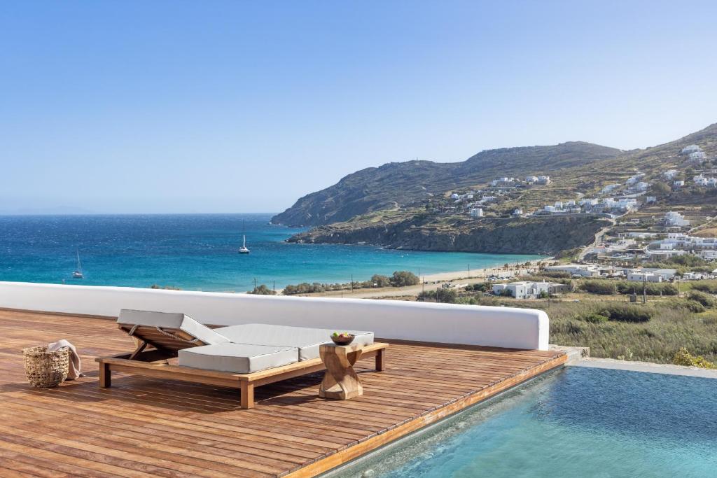 een terras met een bank en een zwembad met uitzicht op de oceaan bij Mileo in Kalo Livadi