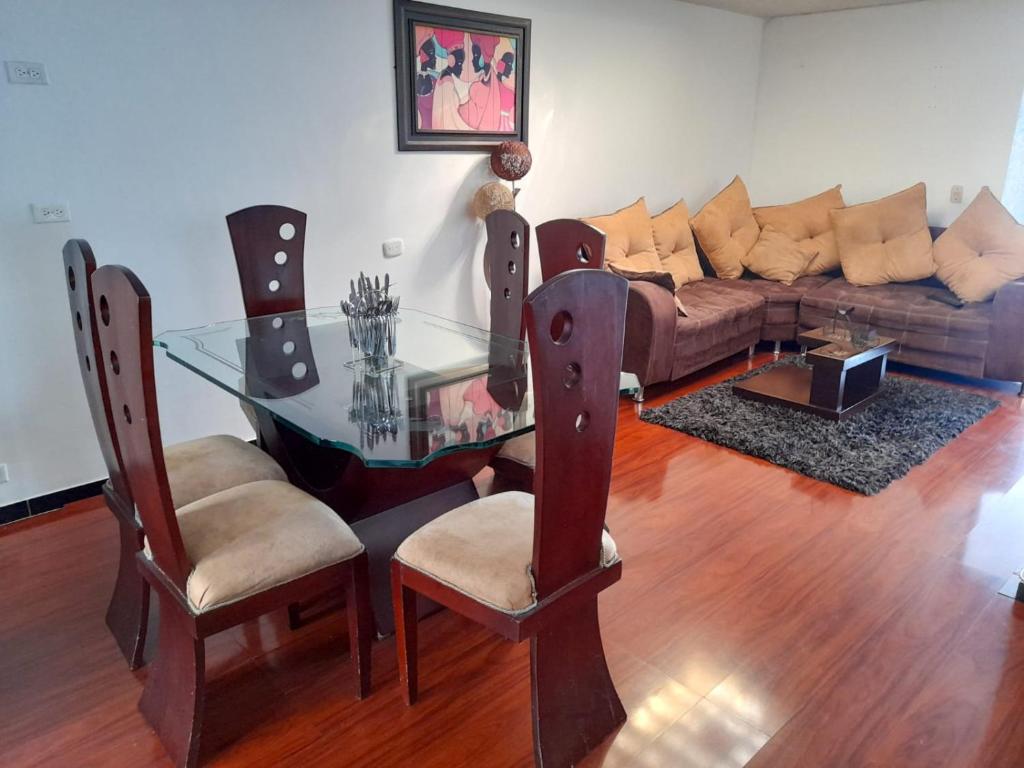 sala de estar con mesa de cristal y sofá en Apartamento muy amplio, Familiar cerca al Aeropuerto el Dorado, en Bogotá