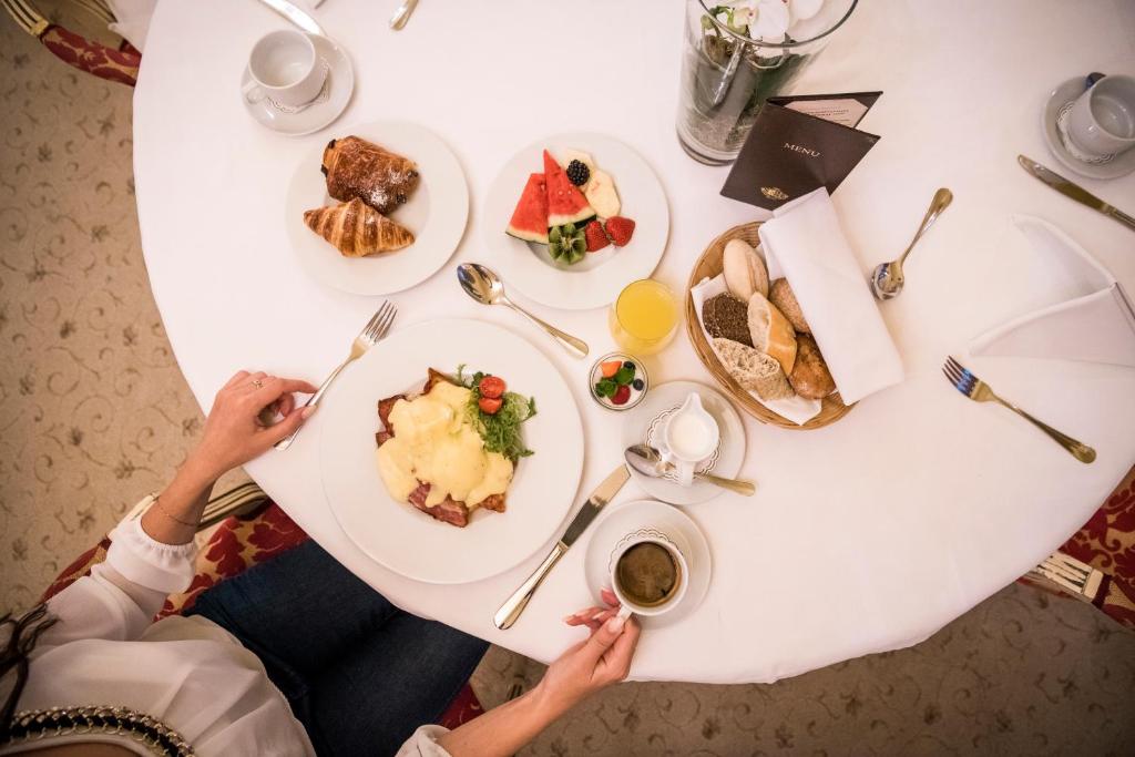a person sitting at a table with a plate of food at Alchymist Grand Hotel and Spa - Preferred Hotels & Resorts in Prague