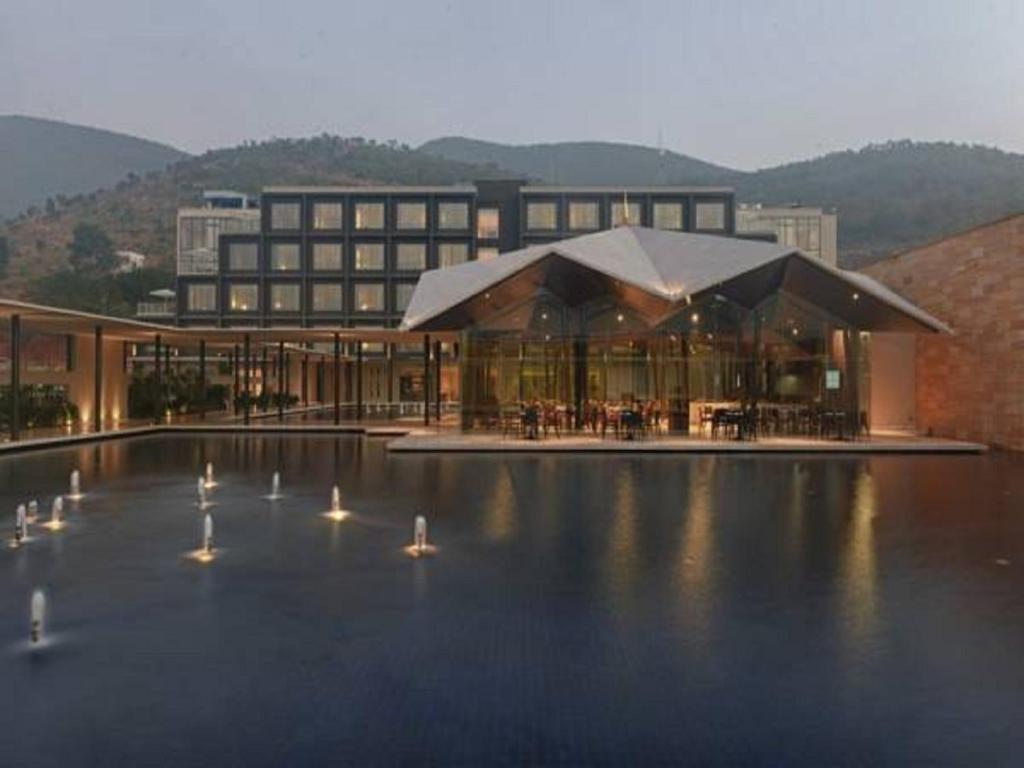 a building with a pool with birds in front of it at Marasa Sarovar Premiere in Tirupati