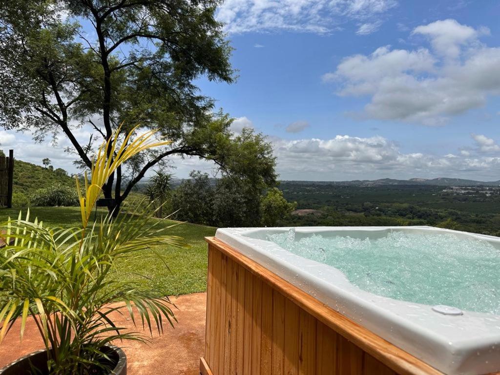 a bath tub sitting on top of a wooden fence at Hazyview Accommodation, Bon Repose Cottages 3&4 in Hazyview