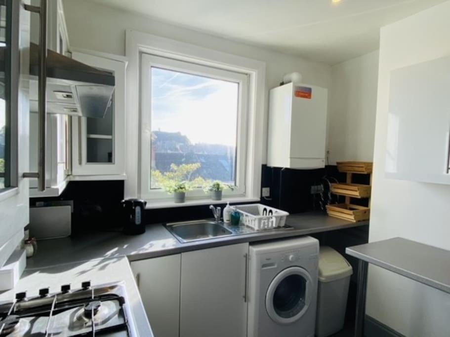 uma cozinha com um lavatório e uma máquina de lavar roupa em Castle View 2 Bedroom Apartment in Town Centre em Hastings