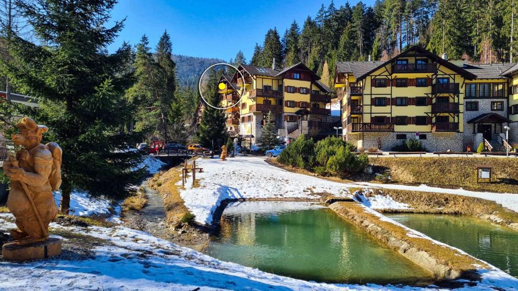 un complexe dans les montagnes avec un étang dans la neige dans l'établissement Zlatý Apartmán, Hrabovo 21, à Ružomberok