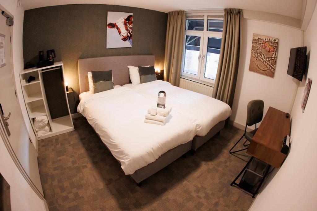 Un dormitorio con una cama grande y una ventana en Stadshotel Rijssen, en Rijssen