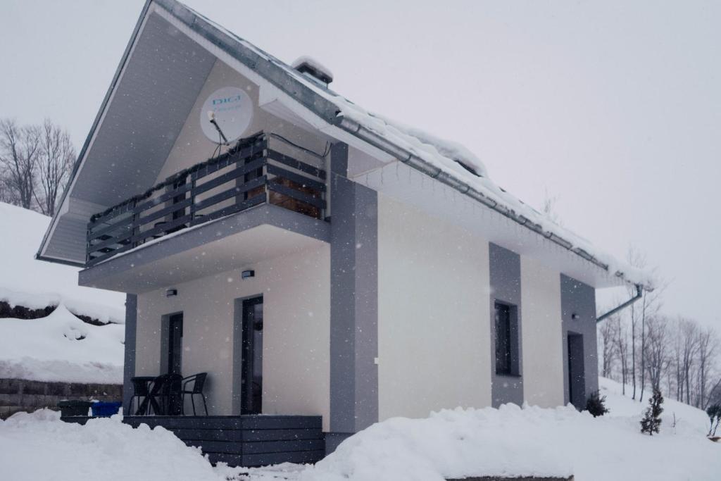 a snow covered house with a balcony on top of it at Chata Dalma in Vígľaš