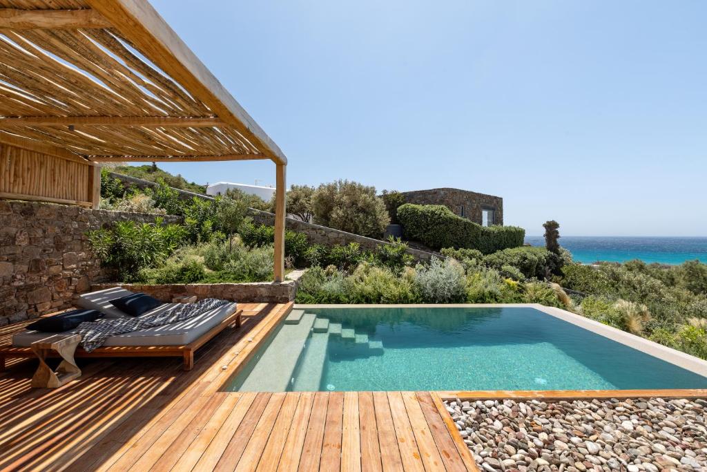 una piscina en una terraza de madera junto al océano en Mileo en Kalo Livadi