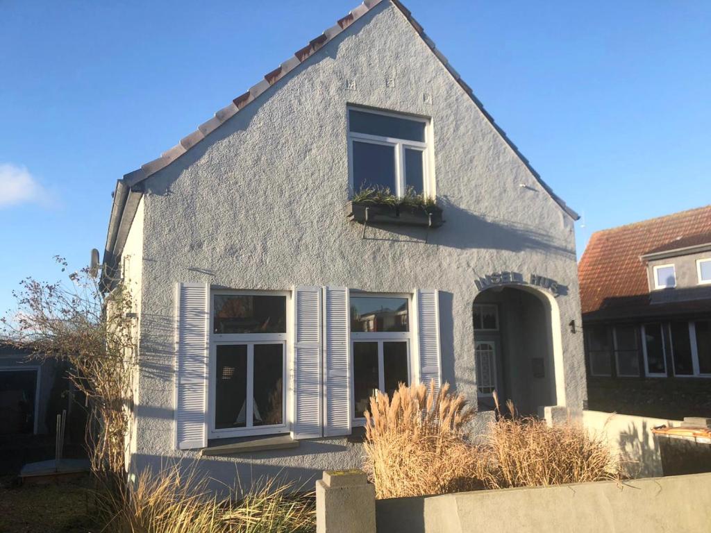 een wit huis met een raam en een plant bij Insel Hus in Fehmarn