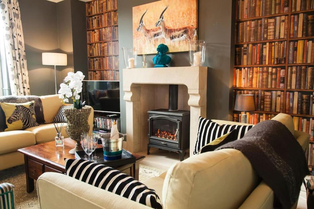 a living room with couches and a fireplace and books at SUNNYBECK COTTAGE Award winning DOG friendly in Settle