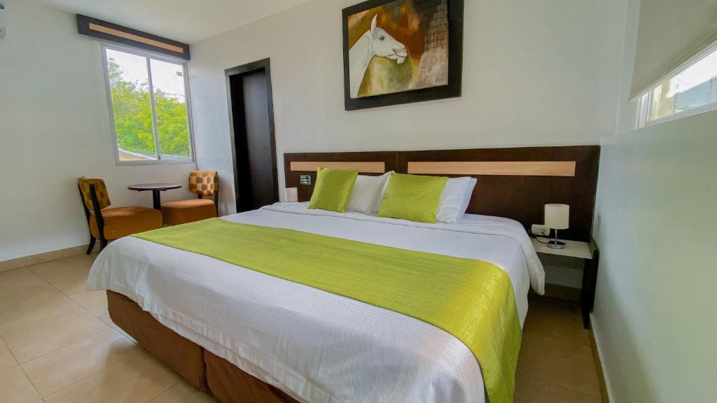 a bedroom with a large bed with a green blanket at MC Suites Boutique in Guayaquil