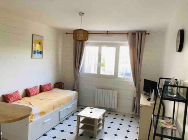 a bedroom with a large bed and a window at Foch, proximité immédiate plage-port-commerces in Courseulles-sur-Mer