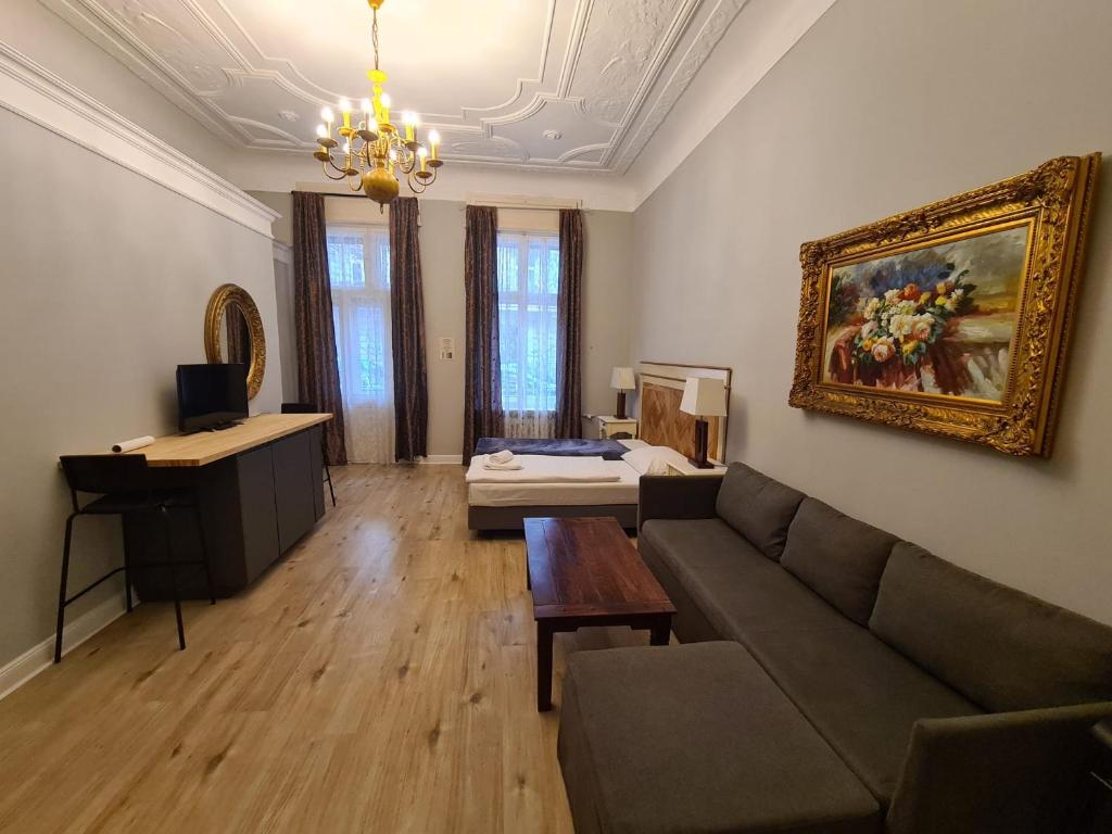 ein Wohnzimmer mit einem Sofa und einem Bett in der Unterkunft Apartments-Maison Am Olivaer Platz in Berlin