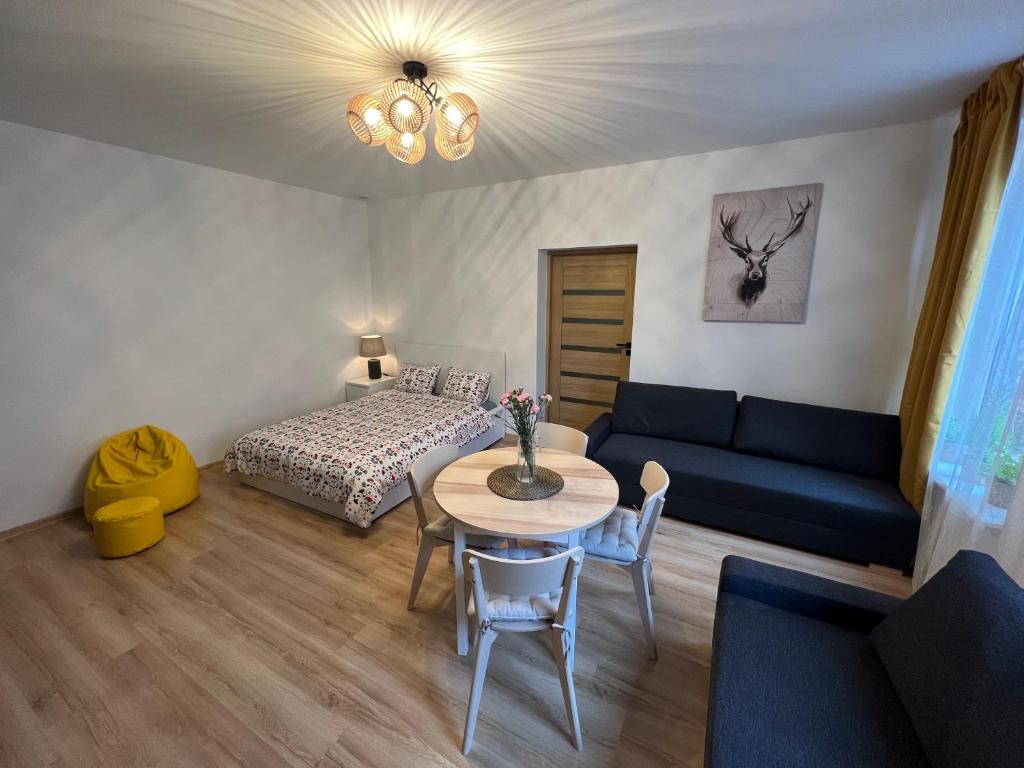 un soggiorno con divano, tavolo e letto di Wood Apartment z Konsola X-Box a Katowice
