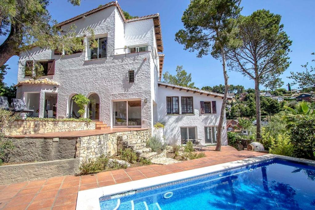 eine Außenansicht eines Hauses mit Pool in der Unterkunft Catalunya Casas Majestic Villa and Views , 30km to Barcelona in Corbera de Llobregat