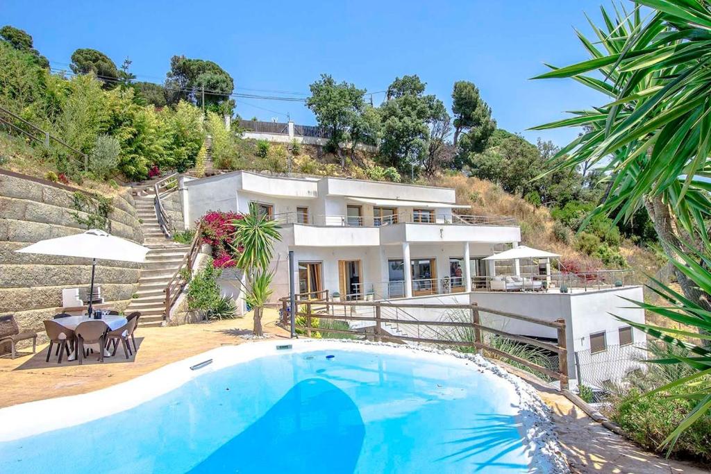 een huis met een zwembad ervoor bij Catalunya Casas Modern Magnificence , only a few km to the beach! in Sant Cebrià de Vallalta