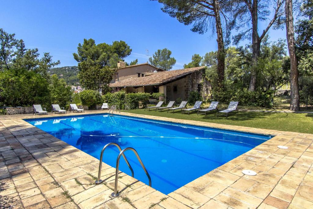a swimming pool with chairs and a house at Catalunya Casas Heavenly Haven for 16 pax , 30km from Barcelona! in San Felíu del Racó