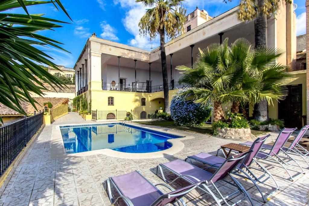 Banyeres del PenedesにあるCatalunya Casas Impressive and Idyllic mansion for up to 40 people!のスイミングプール、椅子が備わるヴィラです。