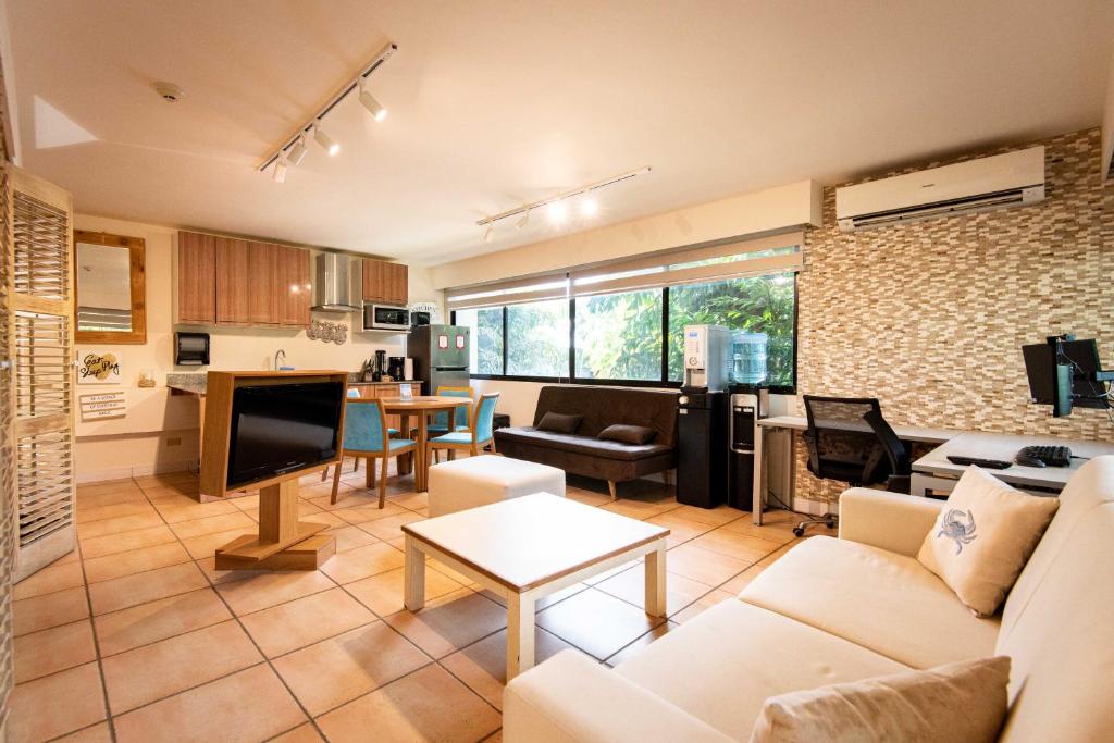 sala de estar con sofá y cocina en La mejor Garden Suite Privada del complejo Coronado Luxury Club and Suites, en Playa Coronado
