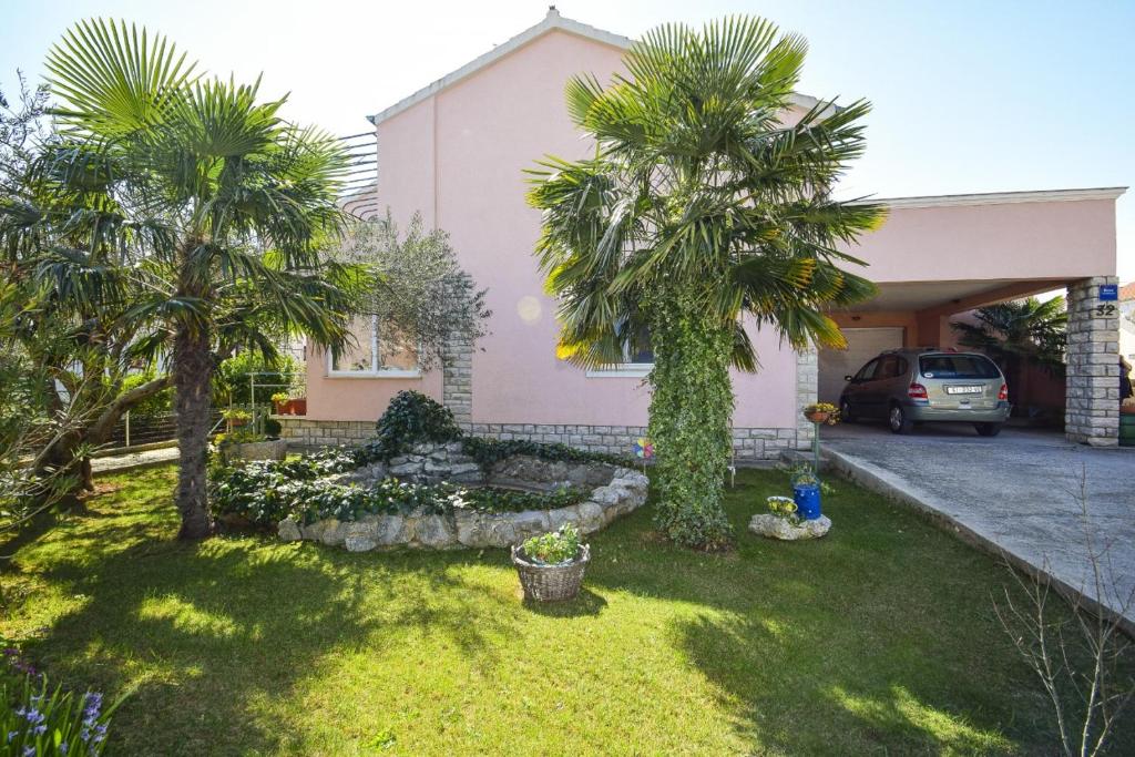 una casa con dos palmeras en un patio en Apartmani Ferara Vodice, en Vodice