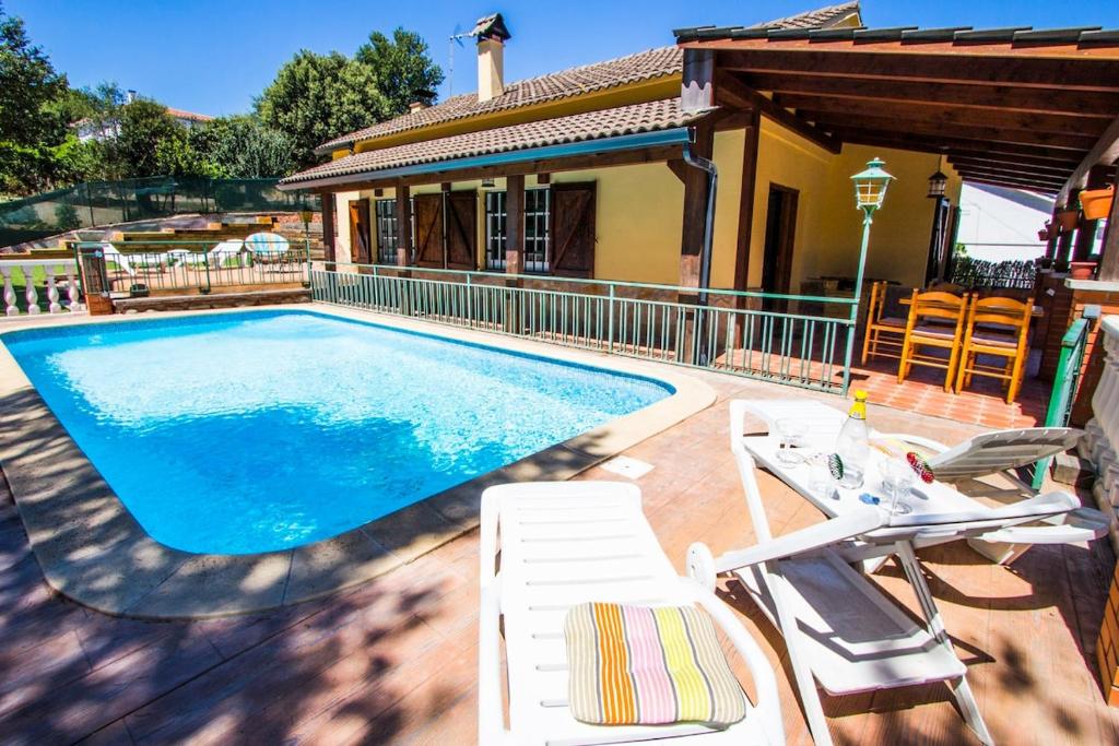 a swimming pool with chairs and a house at Catalunya Casas Costa Brava villa with private pool & spacious garden in Santa Coloma de Farners