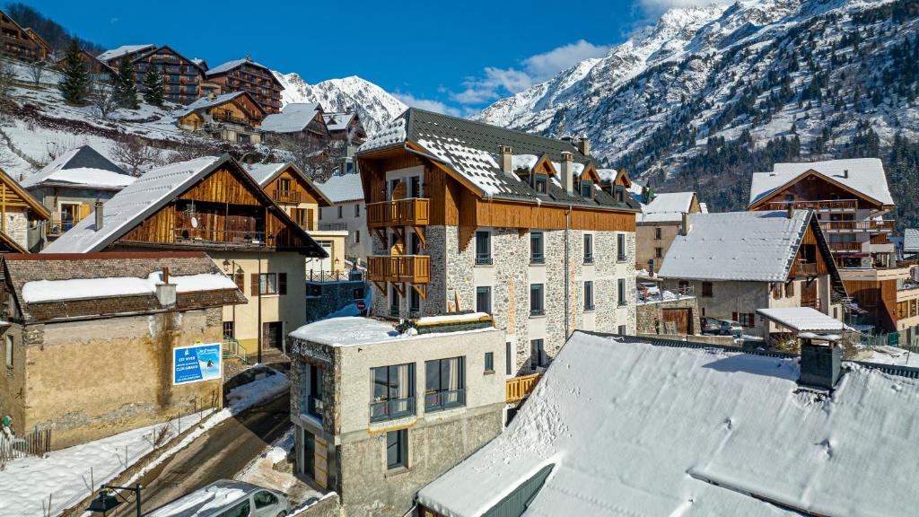 une vue aérienne sur une ville avec des bâtiments recouverts de neige dans l'établissement Madame Vacances Hotel Les Cimes, à Vaujany