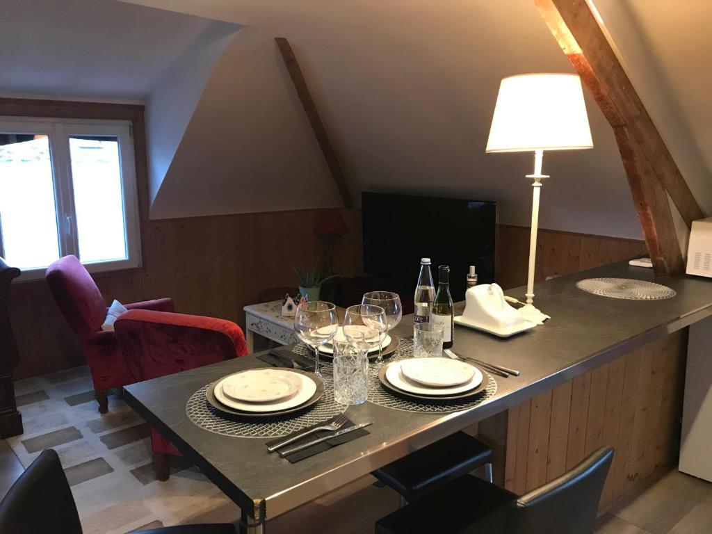 a dining table with wine glasses and a lamp on it at Appartement Cosy Chelles in Chelles