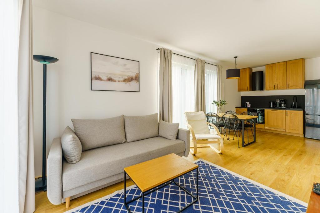 a living room with a couch and a table at Apartament SEAGRASS SurfingBird Dźwirzyno in Dźwirzyno